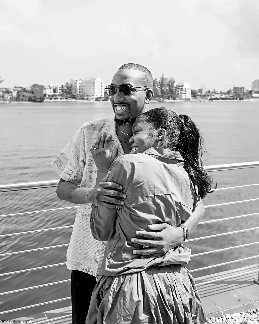 ekanem and adeilé embracing on a waterside deck, black and white